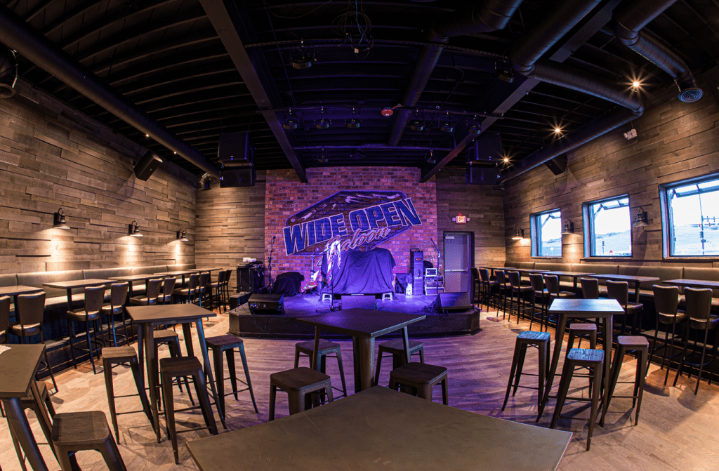 Wide Open Saloon stage with blue lights and booths