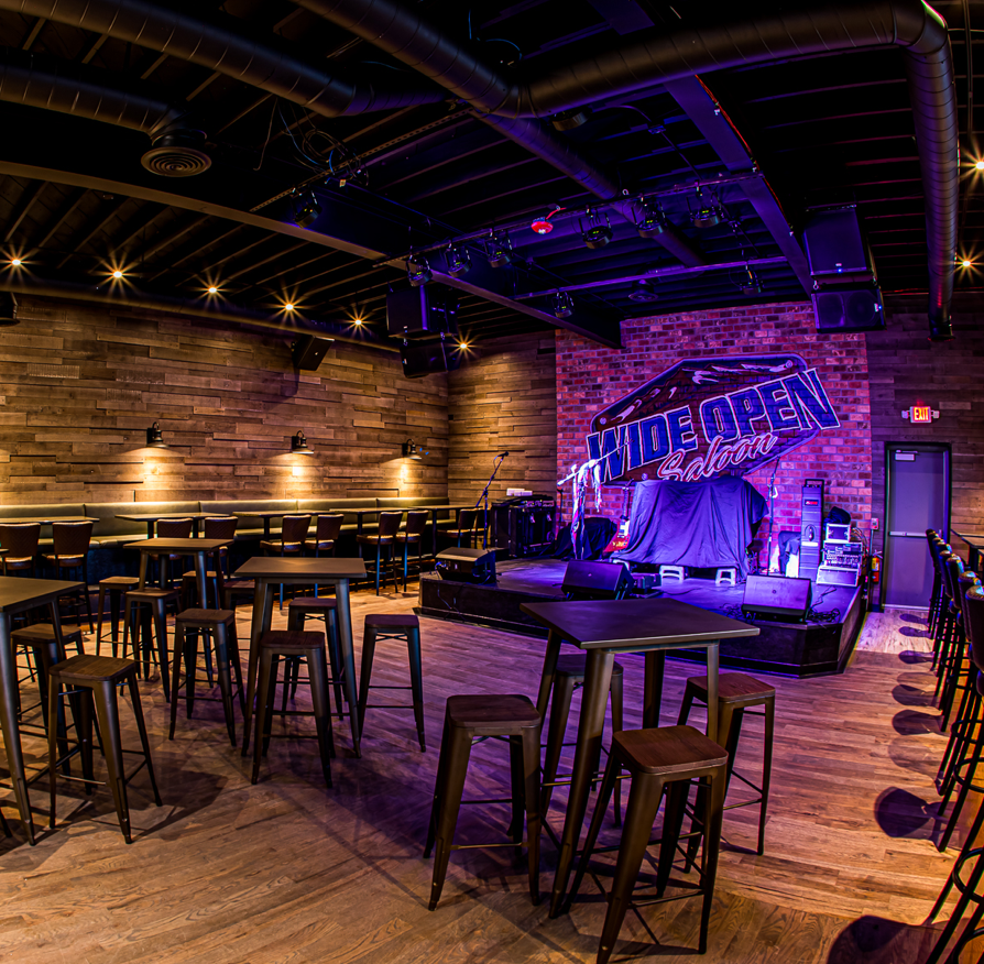 Wide Open Saloon hight tables with a stage in blue lights